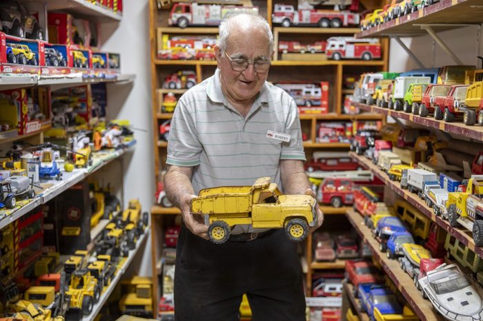 A visitor holding a collectable toy truck in front of shelves of them