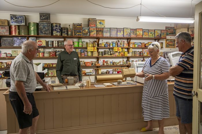 Visitors talking at the counter of the recreated grocery shop